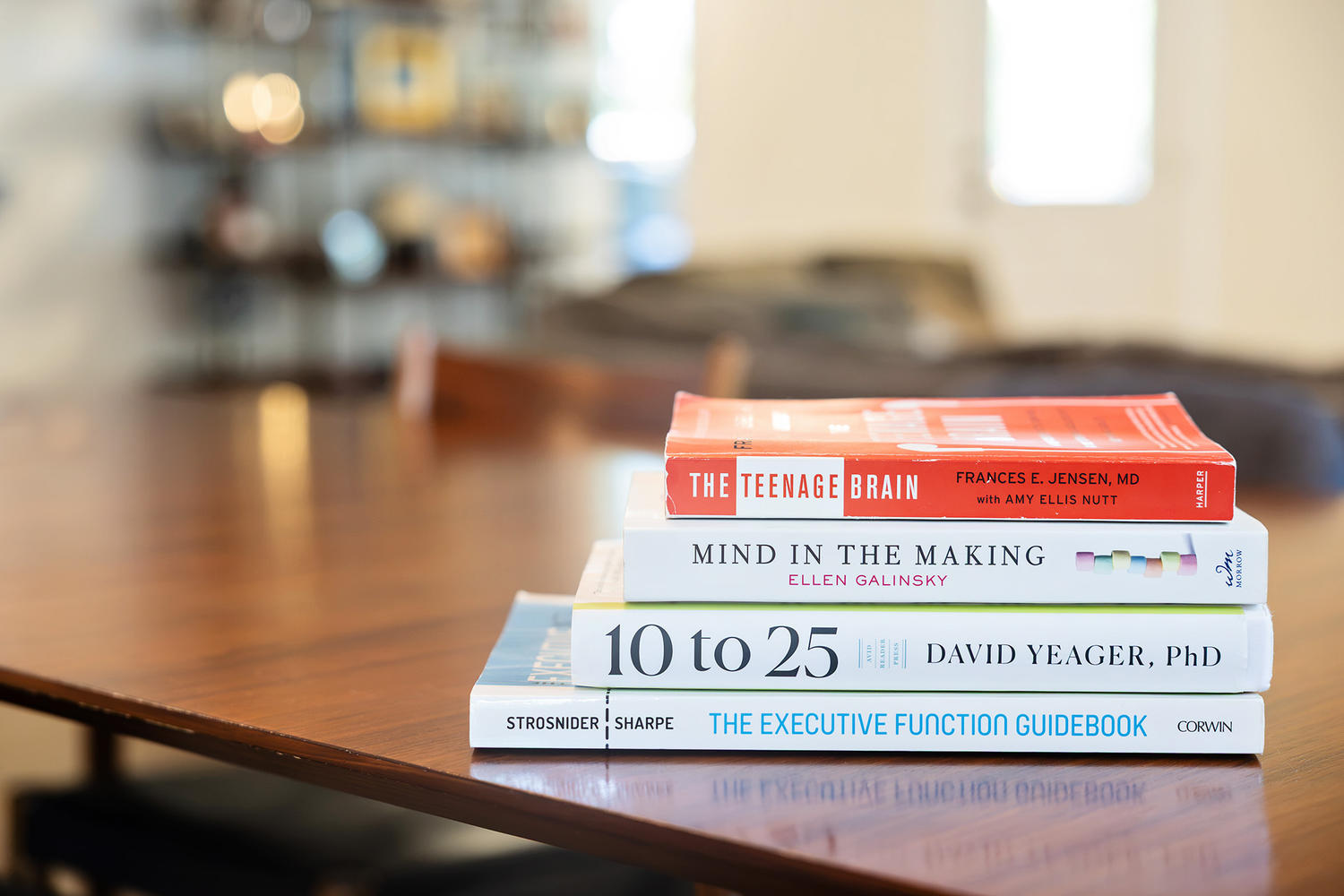 Stack of parenting and executive functioning books on a table